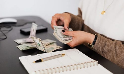 crop-payroll-clerk-counting-money-while-sitting-at-table